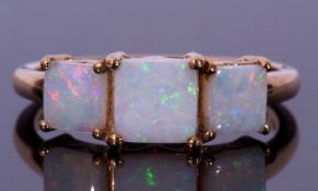 Modern 9ct gold and white opal three stone ring featuring three graduated square cut white opals,