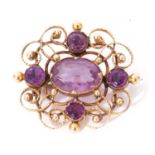 Yellow metal and amethyst brooch, the ornate scroll and bead openwork frame decorated with five