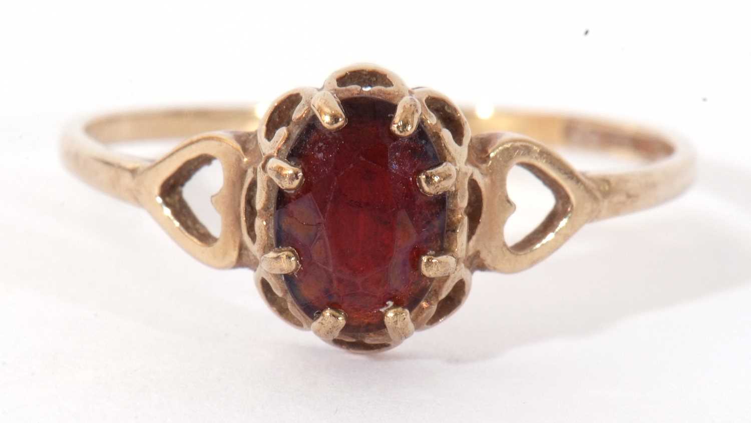 9ct gold garnet ring, multi-claw set and raised between open work heart shoulders, size N