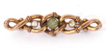 Vintage 9ct stamped open work scroll brooch centring a round cut peridot in cut down millegrain edge