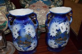 PAIR OF EARLY 20TH CENTURY DOUBLE HANDLED VASES DECORATED WITH ARABIAN OASIS SCENES
