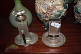 A SILVER PLATED MATCHBOX STAND AND A FURTHER SILVER PLATED CANDLESTICK (2)