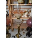 OIL LAMP WITH BRASS COLUMN BASE, CLEAR GLASS FONT AND A FRILLED TINTED SHADE
