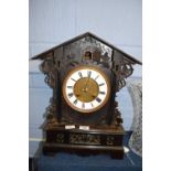 Dark wooden ornately carved cuckoo clock together with carved wooden shelf carved with an eagle,