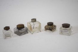 Small box containing five glass inkwells with metal covers