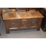 18th century oak coffer with three panelled top over a front with three carved panels raised on