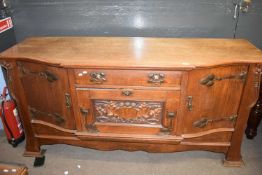 Late 19th century oak sideboard in the Arts & Crafts style, the bowed front with three doors and a