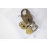 Box containing four small vintage padlocks with keys