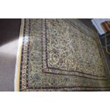 Large Meshed wool floor rug decorated with stylised floral detail on a pale background surrounded by