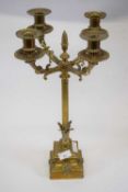 Four branch brass candelabra, central Corinthian column with acorn type knop, supported by square