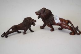 Two carved wooden models of lions with glass eyes