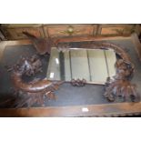 Late 19th/early 20th century Continental wall mirror with shaped carved wooden surround formed as