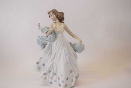 A Lladro model of a young girl with small bird seated on her flowing shawl factory mark to base with