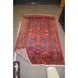 20th century Middle Eastern wool floor rug decorated with a large central panel with lozenges and