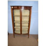 Edwardian mahogany bow front two door display cabinet with shelved interior, raised on tapering