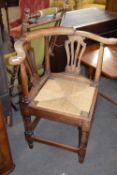 Large Georgian elm framed bow back corner chair with pierced splat over a push out rush seat and