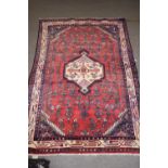 20th century Middle Eastern wool floor rug decorated with a pale central medallion surrounded by