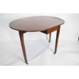 Late 19th century mahogany oval drop leaf table raised on tapering legs with brass end caps and