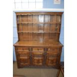 Good quality reproduction oak dresser with moulded cornice and two shelves to back over a base