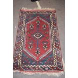 Small 20th century Middle Eastern wool floor rug with large central red lozenge, 127 x 76cm