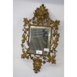 Small rectangular mirror within an ornate metal frame featuring Green Man type figure above and