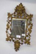 Small rectangular mirror within an ornate metal frame featuring Green Man type figure above and