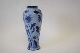 A Moorcroft vase with a tube lined floral pattern on a blue ground.20cm highGood condition