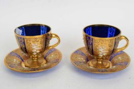 Quantity of cups and saucers, blue glass overlaid with gilt and painted floral designs with birds (