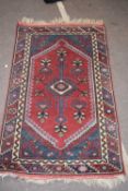 Small 20th century Middle Eastern wool floor rug with large central red lozenge, 127 x 76cm