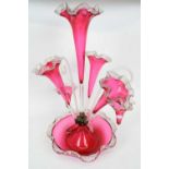 Late 19th century cranberry glass epergne with a central vase, three flower holders and two small