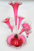 Late 19th century cranberry glass epergne with a central vase, three flower holders and two small