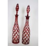 Pair of decanters with tear drop stoppers in Bohemian style with ruby overlay