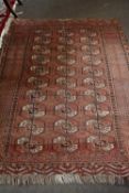 Middle Eastern wool floor rug decorated with central panel of octagonal lozenges on a principally