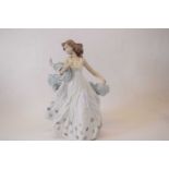 A Lladro model of a young girl with small bird seated on her flowing shawl factory mark to base with
