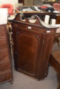 Georgian mahogany wall mounted corner cabinet with broken arch pediment over a single panelled