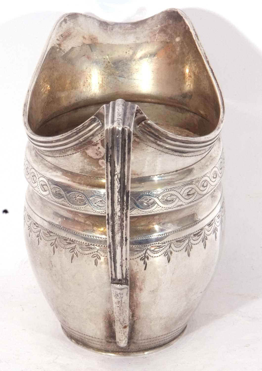 George III helmet cream jug of waisted oval form, bright cut and punched decoration, reeded rim - Image 5 of 5