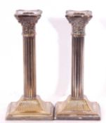 Pair of vintage previously silver plated candlesticks with Corinthian columns standing on square