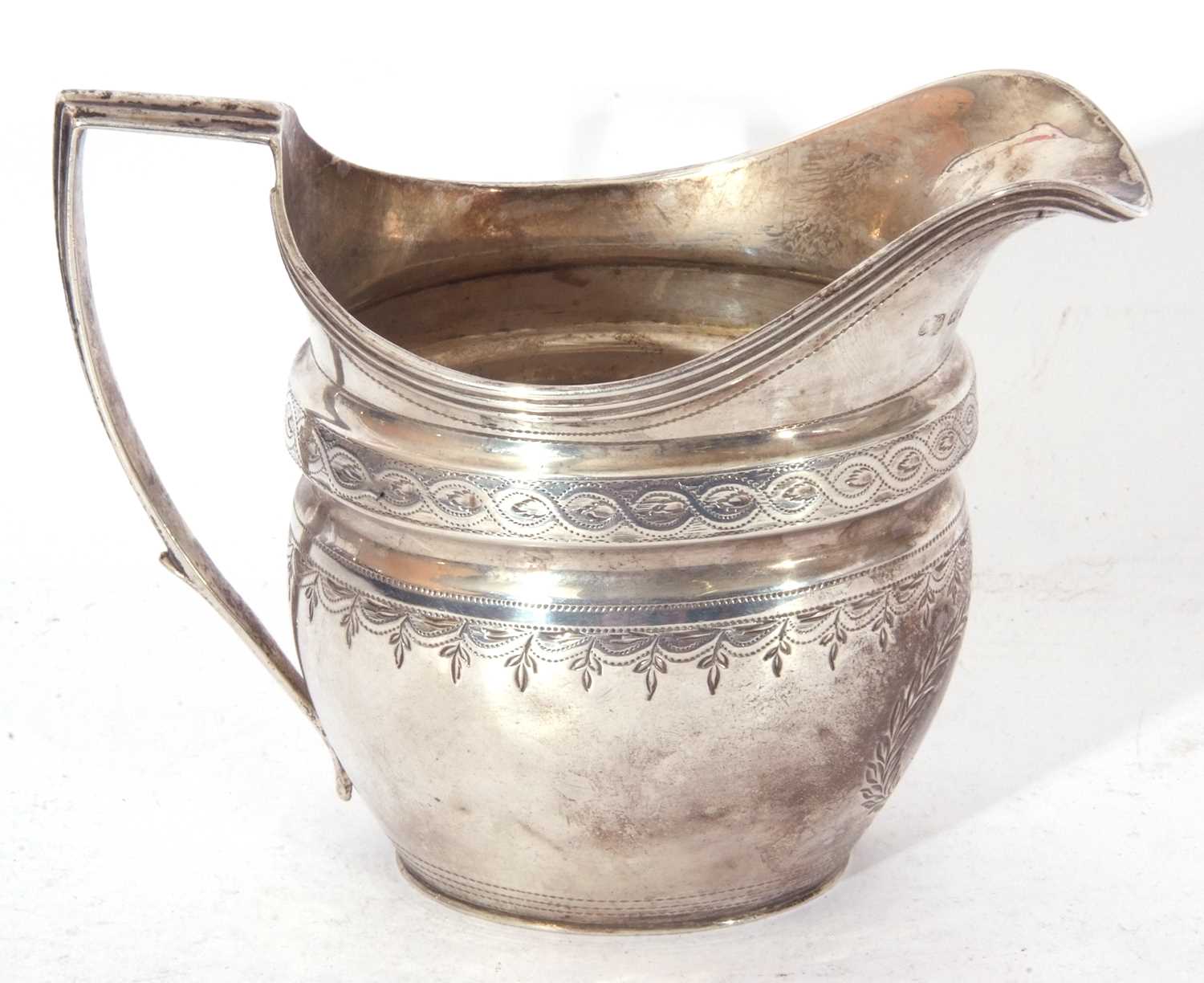 George III helmet cream jug of waisted oval form, bright cut and punched decoration, reeded rim - Image 2 of 5