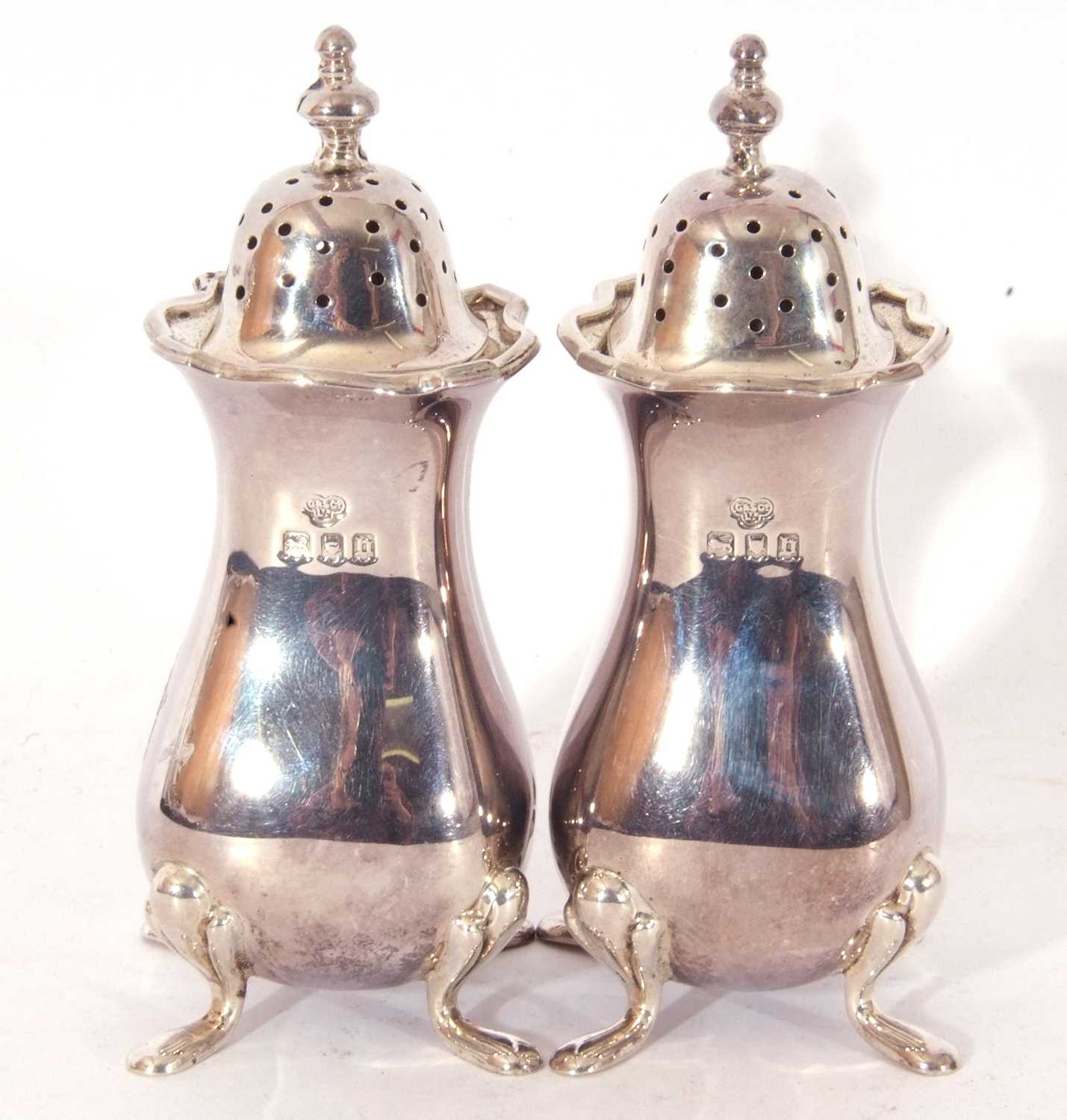Pair of George V heavy gauge baluster casters with card cut rims, urn finials and each supported