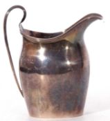 George V small helmet cream jug in George III style, having reeded rim and looped handle, 10cm tall,