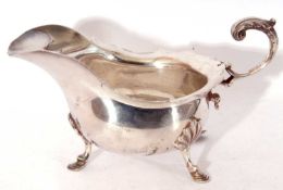 Edward VII silver sauce boat of typical form, card cut rim with flying scroll cap leaf handle on