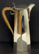 George V silver hot water jug of plain polished octagonal form, the hinged lid with plain thumb