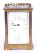 Brass carriage clock timepiece with white enamel dial and Roman numerals, plus a sub-second dial,