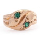 9ct gold double headed serpent ring, the heads each set with a round cut green stone, the shank a