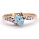 Modern 9ct gold aquamarine and diamond cross-over ring, the oval faceted aquamarine offset and