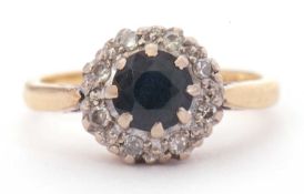 18ct gold sapphire and diamond cluster ring, centring a round faceted cut sapphire, multi-claw set