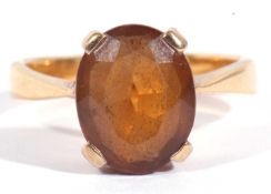Citrine single stone ring of oval faceted shape, 10 x 8mm, basket set in a yellow metal mount, (