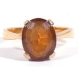 Citrine single stone ring of oval faceted shape, 10 x 8mm, basket set in a yellow metal mount, (