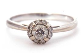 Modern diamond halo ring centring a round brilliant cut diamond surrounded by eight small