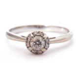 Modern diamond halo ring centring a round brilliant cut diamond surrounded by eight small